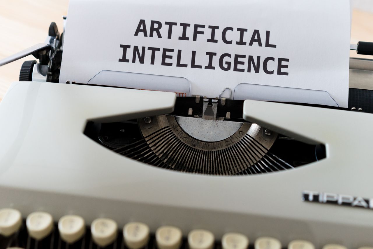 team-04 A close-up of a typewriter showcasing 'ARTIFICIAL INTELLIGENCE' on paper.